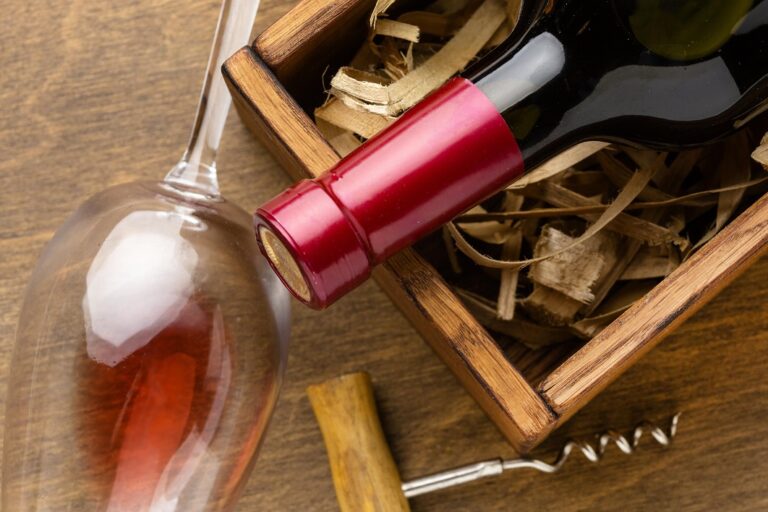 Closeup of bottle of wine, wine glass, and corkscrew.